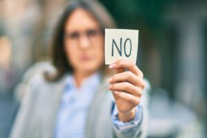 Young hispanic businesswoman with serious expression holding reminder with no message at the city. Wodkaterrorist---DJ-Ludwigsburg-Stuttgart-Hochzeit